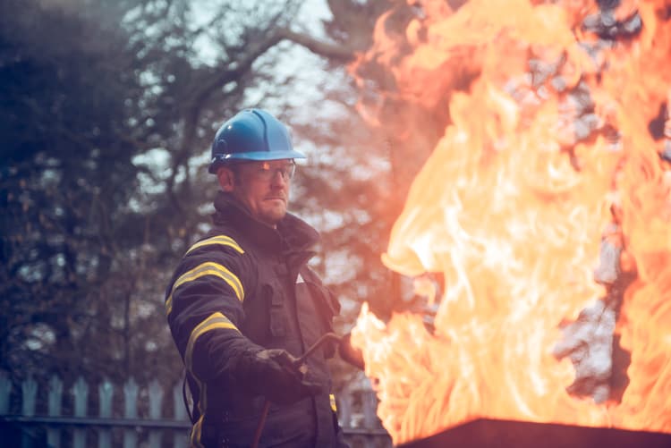 Participant undergoing a GWO Fire Awareness drill, equipped with safety gear, while engaging in real-world fire safety training.