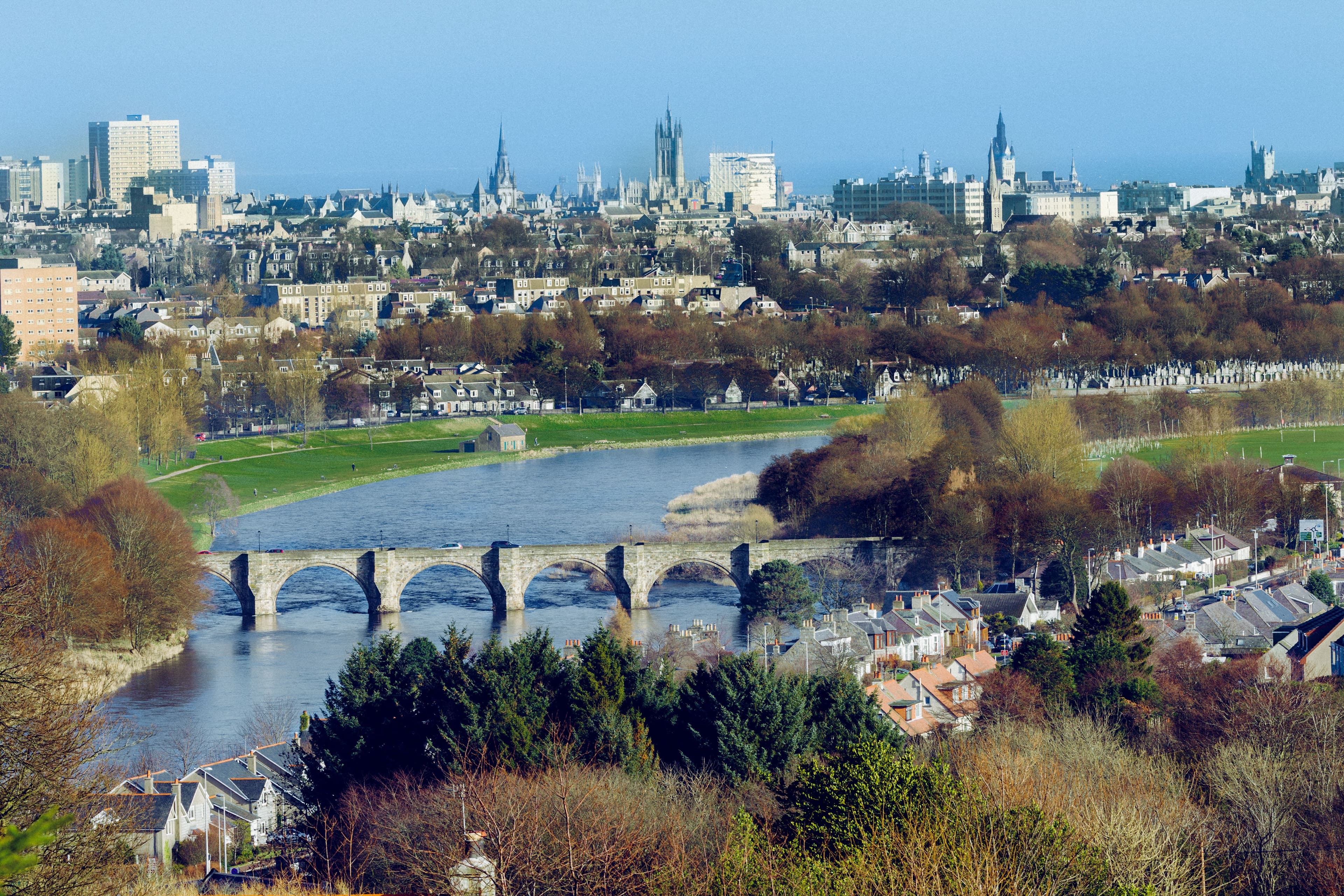 A scenic view of Aberdeen with the historic Bridge of Dee spanning the river, blending the city’s natural beauty with its iconic granite architecture.
